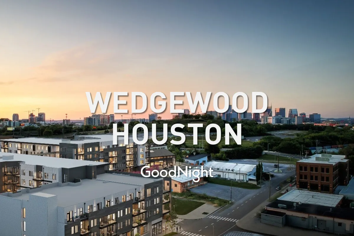 A stylish exterior scene featuring modern architecture against the Nashville skyline at sunset. The rooftop perspective suggests opportunities for evening relaxation or informal gatherings, with nearby dining and city life just steps away.