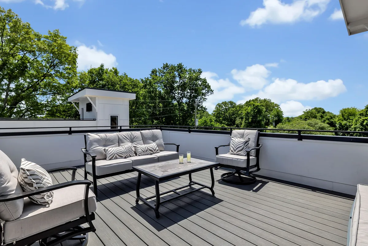 An inviting outdoor seating arrangement with plush chairs and a coffee table, surrounded by lush greenery and set against a sunset backdrop. The space is ideal for both intimate moments and small group gatherings, highlighting its flexibility and comfort.